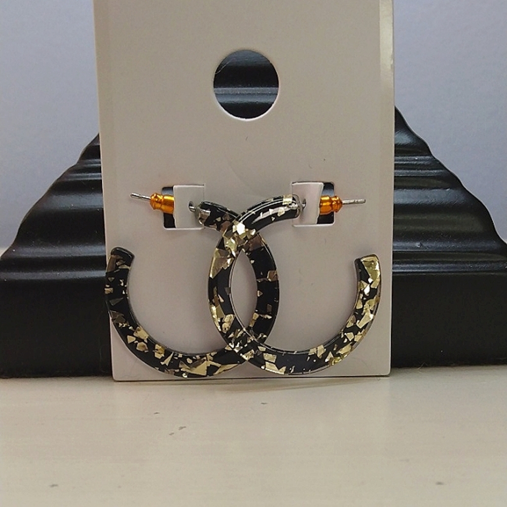Elegant Black flat hoop earrings with gold flakes.